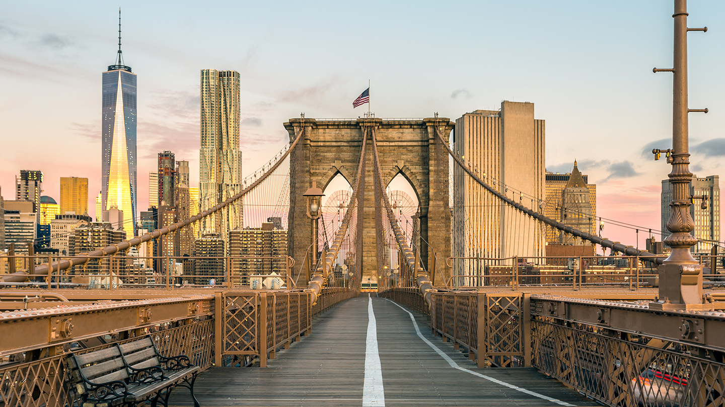 The Famous Brooklyn Bridge at Sunrise, New York City, USA. The sun is rising over Brooklyn on this beautiful day of Autumn