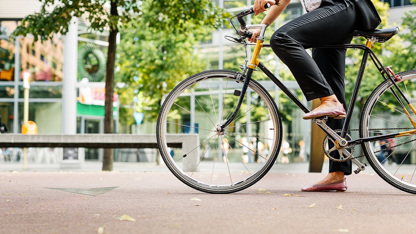 Close up shot of businesswoman's legs riding a bicycle