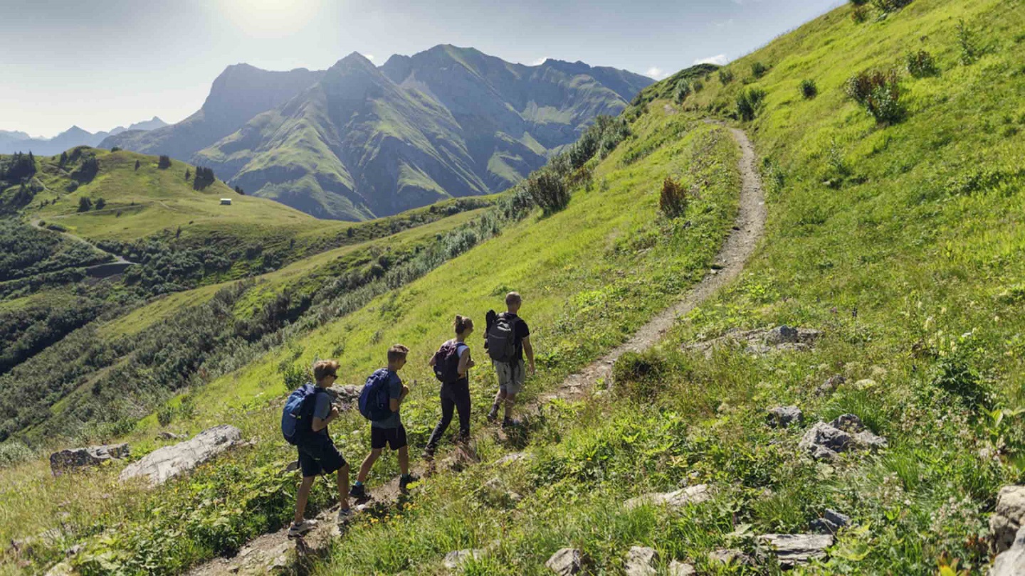 Father and teenage kids hiking in the Alps - Vorarlberg, Austria. They are walking on the footpath in the high mountains of Austria.
Canon R5